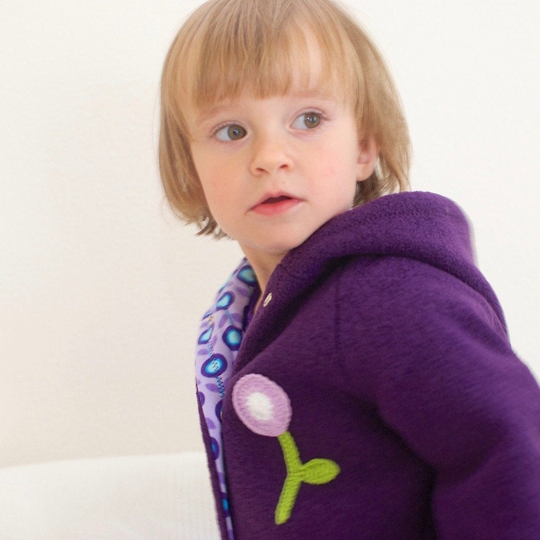 Lila Walkoverall aus Schurwolle mit Baumwollfutter und Häkelblume für Mädchen