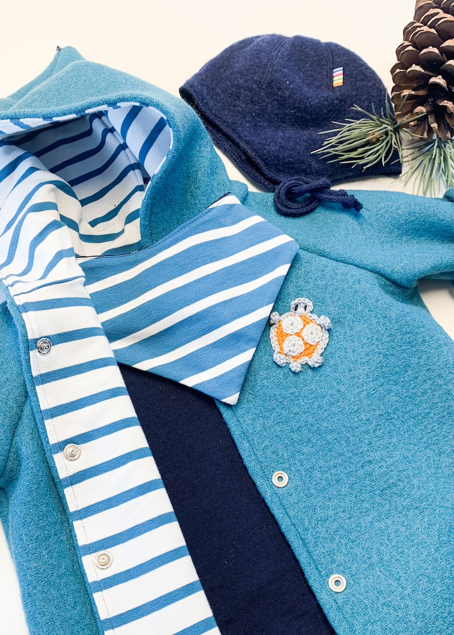 Detail zum Baby Geschenkset "Kuschelzeit" bestehend aus einem Baby Walkoverall in Petrol, gestreiften Baby Halstuch und Body und Mütze aus Merinowolle in Dunkelblau
