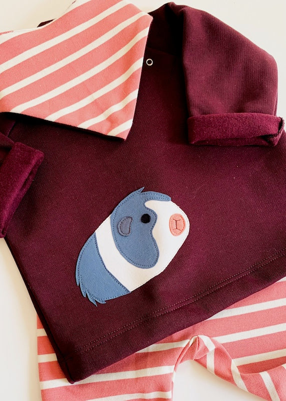 Babygeschenke Bio - Baby Set mit Meerschweinchen-Pullover aus 100% Bio Baumwolle - Detailaufnahme des dreiteiligen Baby-Set mit gestreifter Baby Hose und passenden Baby Halstuch in Rosenholz-Ecru von internaht aus Dresden