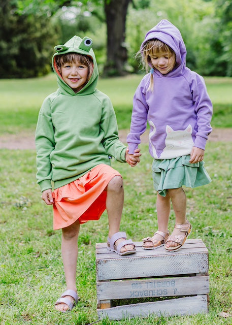 Stufenrock für Mädchen aus Bio-Baumwolle in Lindgrün von internaht - unsere beiden Modells tragen zum lindgrünen Stufenrock unseren Kapuzenpullover mit Katze in Lavendel sowie zum orangefarbenen Stufenrock den Frosch Hoodie
