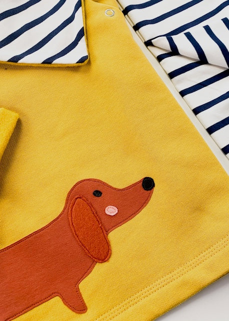 Geschenke zur Geburt -Nahaufnahme des Dackel-Motivs zum Baby-Set bestehend aus Dackel-Sweatshirt in Senfgelb, Baby Halstuch und Baby Hose gestreift in Ecru-Navy - alles aus Bio-Baumwolle und in Deutschland genäht von internaht