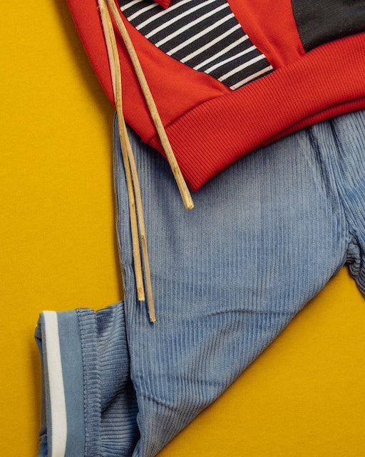 Detail zur Cord Hose für Kinder aus 100% Biobaumwolle von Pigen Organics als Kinder Outfit mit orangefarbenen Kinder Pullover Waschbär von internaht