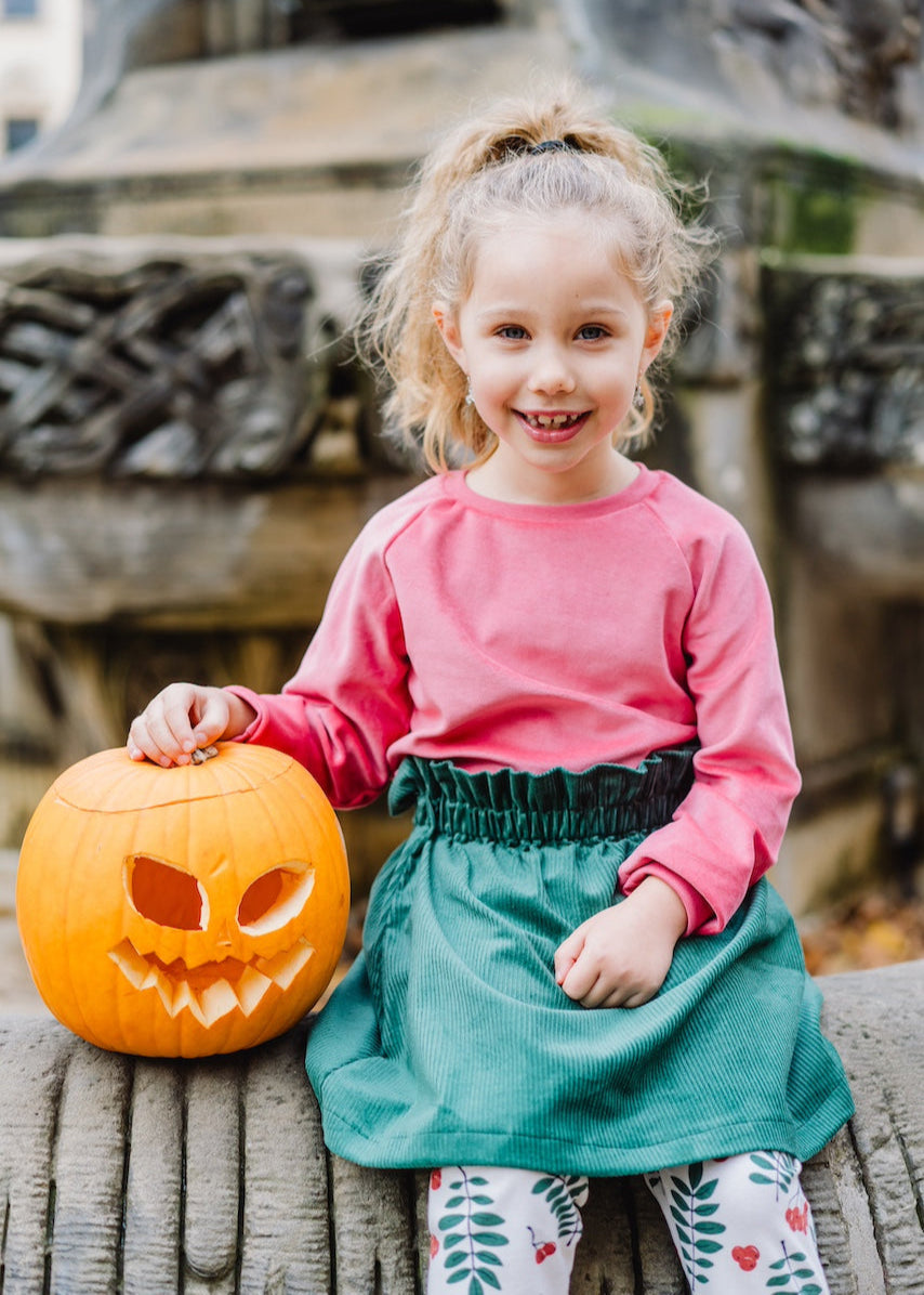 Fröhliches Kinder-Outfit mit Nicki Pullover in Flamingo, Cord Rock in Dunkelgrün und Leggings mit Beeren & Blättern aus Biobaumwolle von internaht