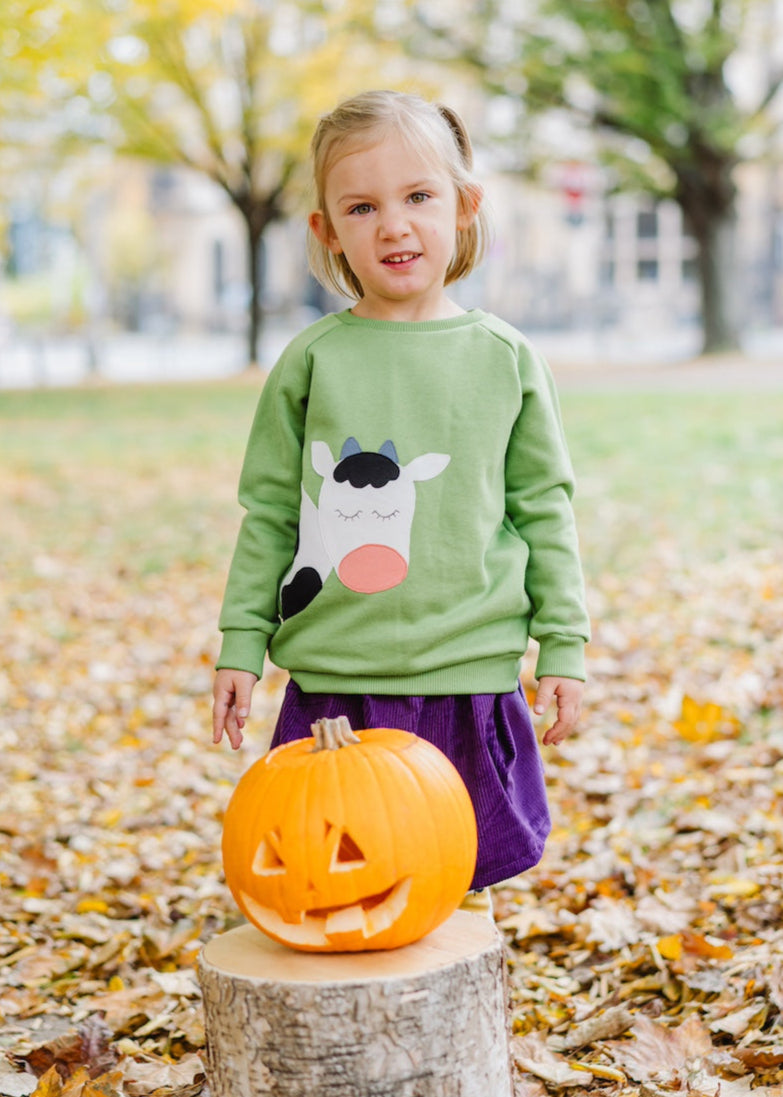 Fröhliches Kinder-Outfit mit Kuh-Sweater, Cord Rock in Lila und Leggings mit Äpfeln Gelb aus Biobaumwolle von internaht