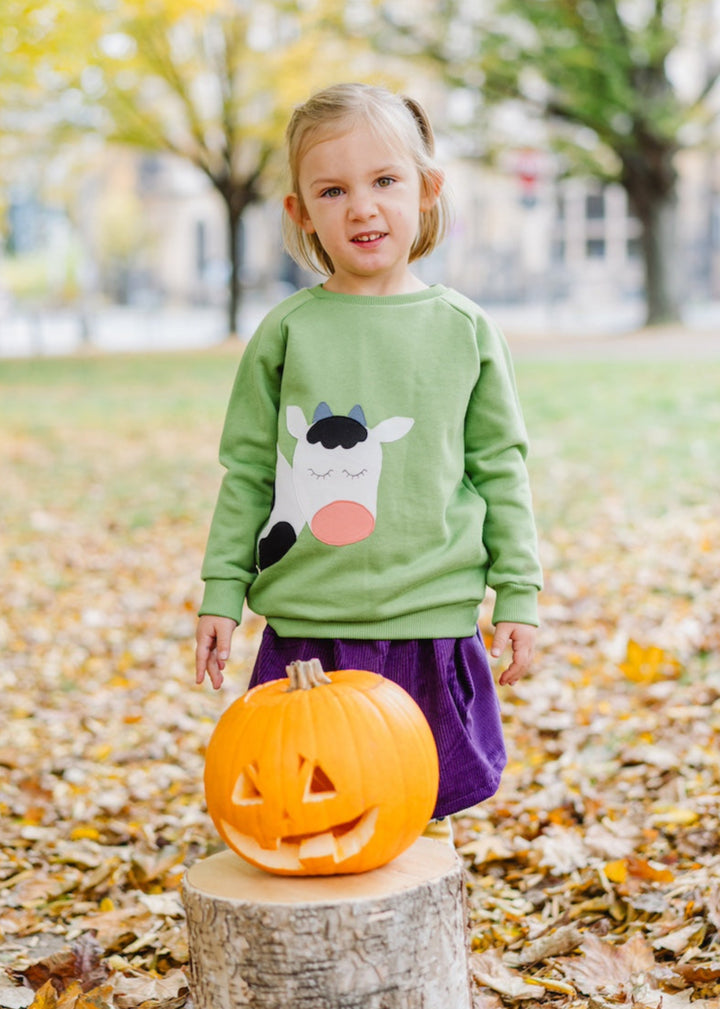 Fröhliches Kinder-Outfit mit Kuh-Sweater, Cord Rock in Lila und Leggings mit Äpfeln Gelb aus Biobaumwolle von internaht